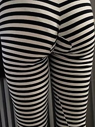 A woman is posing without clothing in a public location