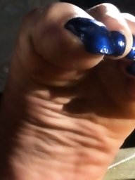 Used red toenails, and soles feet after day at beach